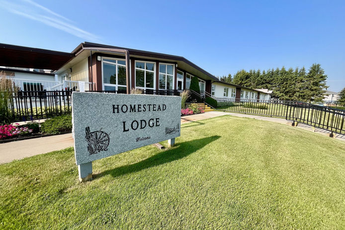 Homestead Lodge sign in front of building and lawn