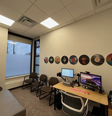 Waiting room with chairs, computers, and vinyl records on the wall