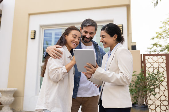 Property agent showing tablet to smiling couple