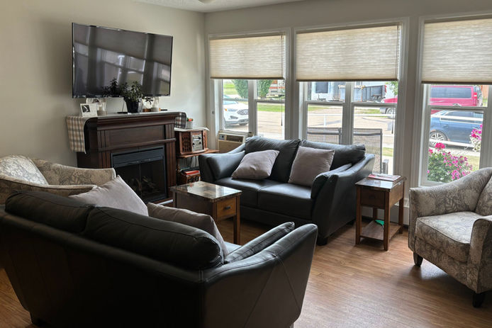 Common living area with sofas and a fireplace at Mannville Seniors Manor.