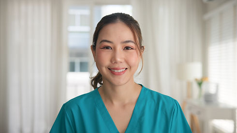 Smiling nurse in teal scrubs providing home nursing care.