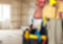 Construction worker holding tool bag in unfinished room development.