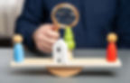 Dividing assets on a scale with magnifying glass