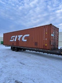 SITC shipping container parked on a flatbed trailer in snowy conditions.