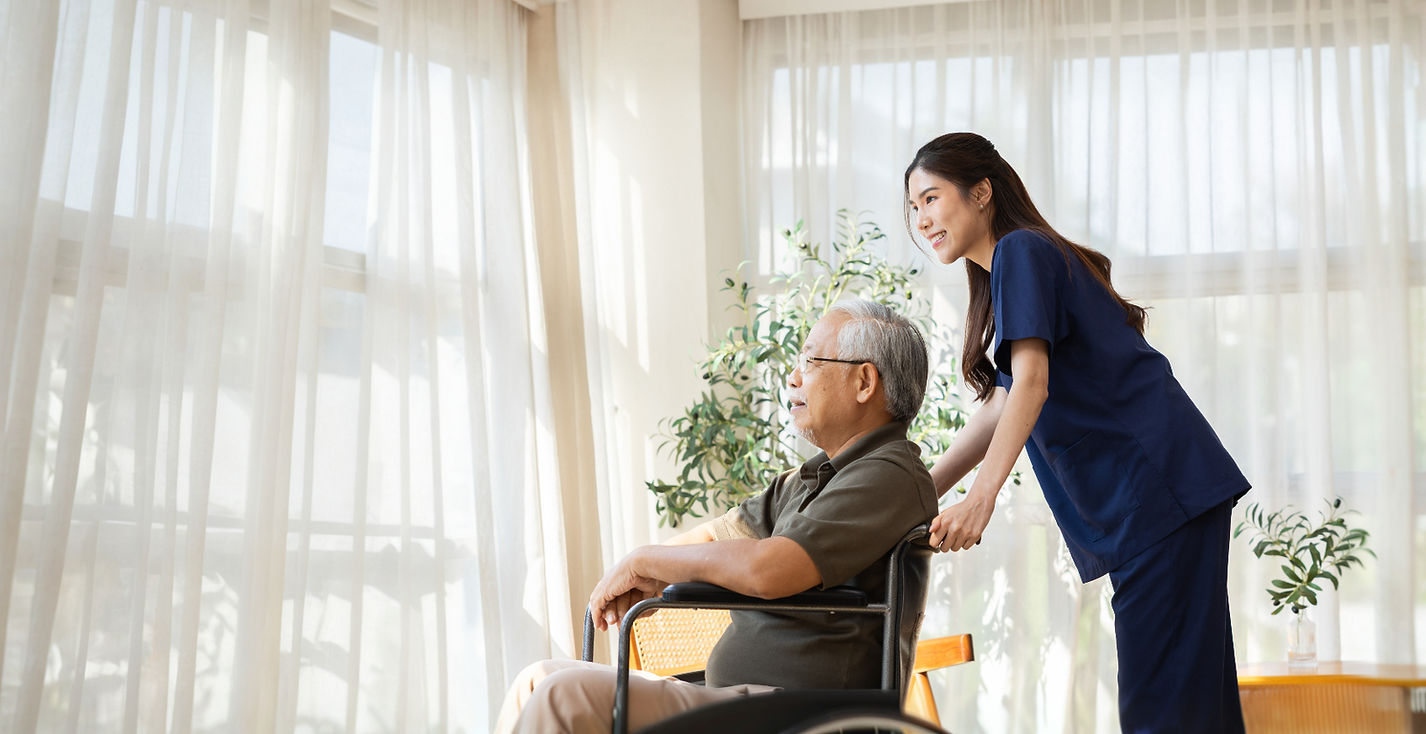 Caregiver pushing a senior man in a wheelchair.