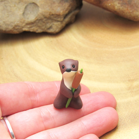 Tiny otter with bulrush ornament