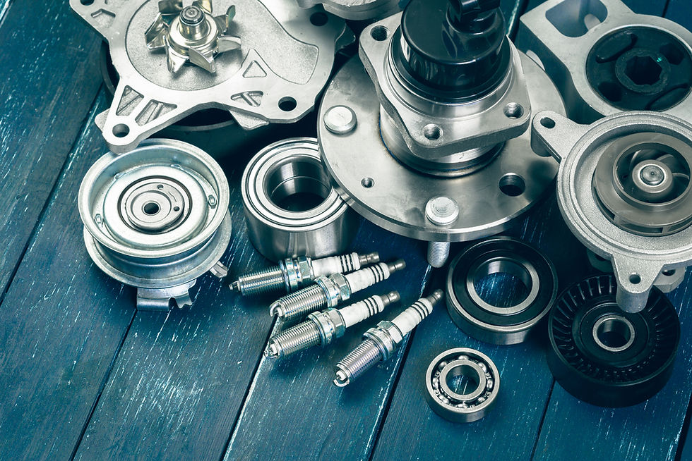 Various aftermarket hydraulic parts, including bearings, spark plugs, and pulleys, laid out on a wooden surface.