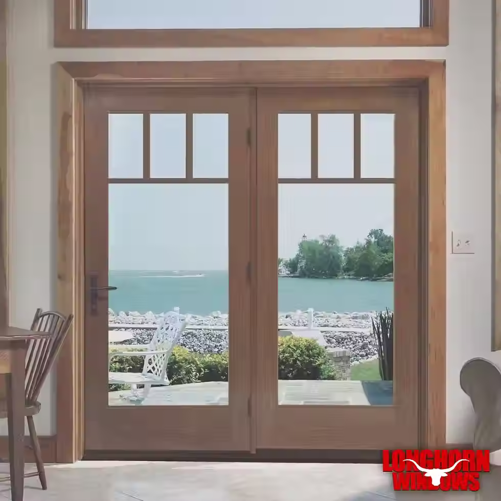 Wood-framed hinged patio doors with divided lite glass panels overlooking a lakefront patio.