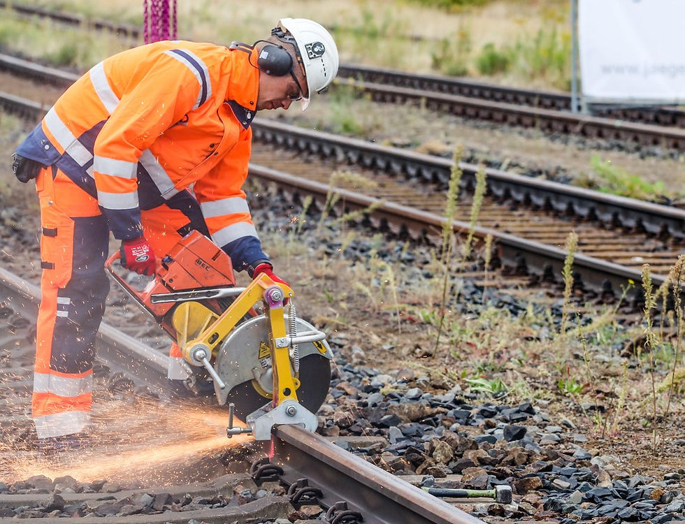 A worker in safety gear operates specialized machinery to maintain and repair railway tracks, ensuring reliable system performance.