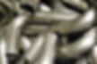A pile of smoothly bent metal pipes, showcasing high-quality hydraulic bending results.