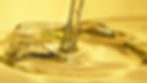 Golden hydraulic oil flowing smoothly with a clear, glossy appearance.
