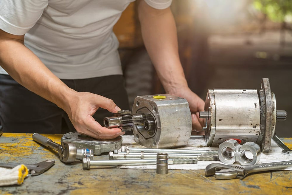 A hydraulic specialist disassembling and inspecting a hydraulic pump on a workbench with tools and components.