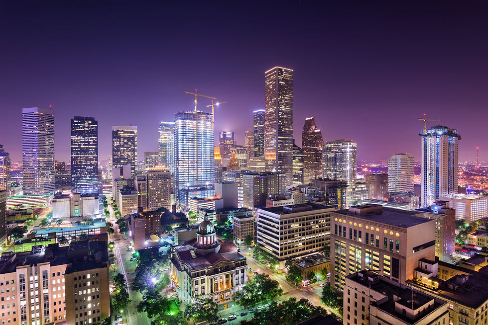 The illuminated Houston skyline at night, symbolizing the city’s industrial growth and technological advancements.