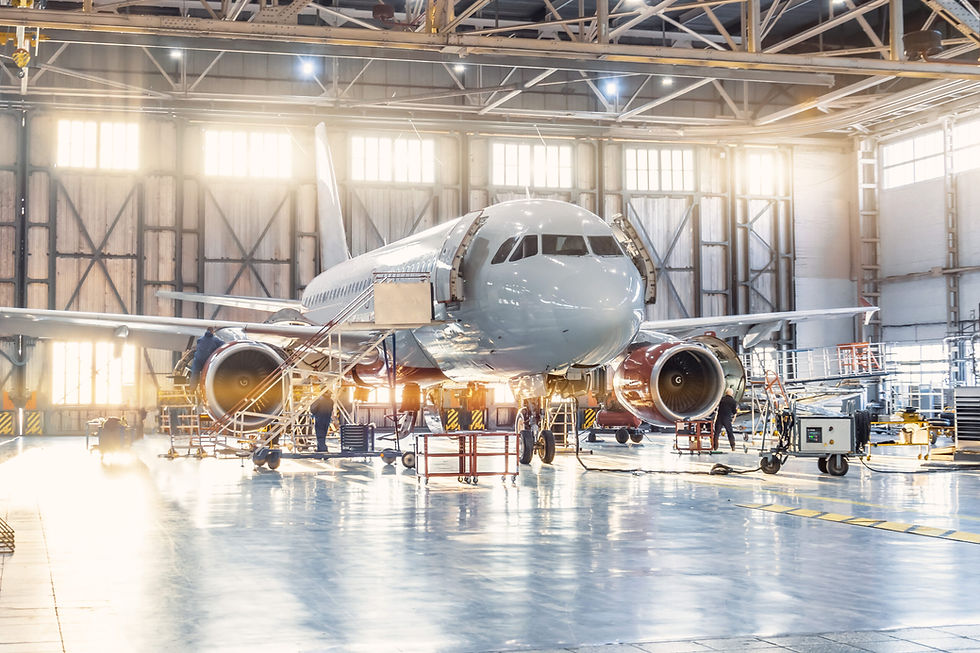 A commercial airplane undergoing maintenance inside a large hangar, highlighting the importance of precision-engineered hydraulic pipe bending in aerospace systems.