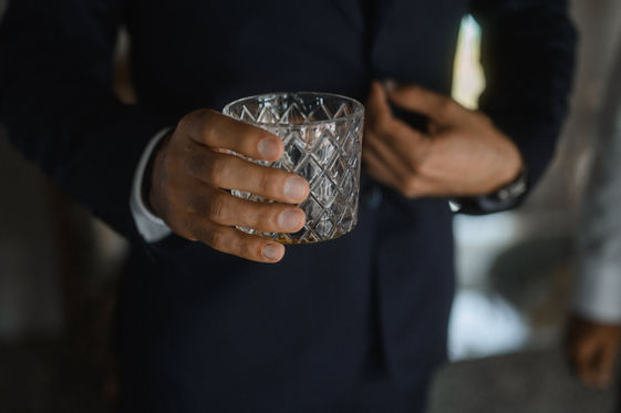 Man in suit holding crystal glass