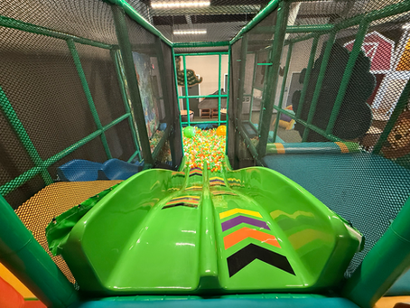 indoor playground at little explorers big green slide into a ball pit