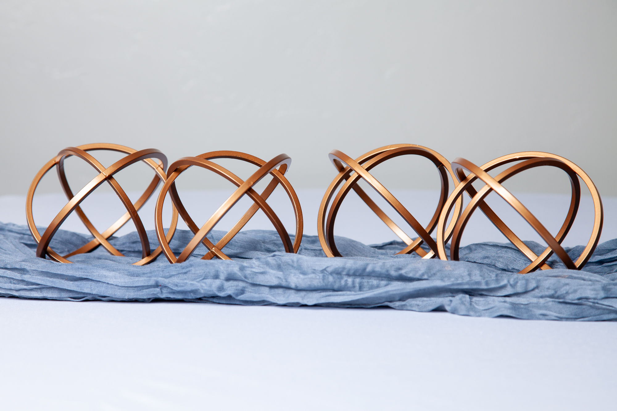 Set of copper metal decorative orbs, perfect for modern wedding centerpieces and party decor rentals.