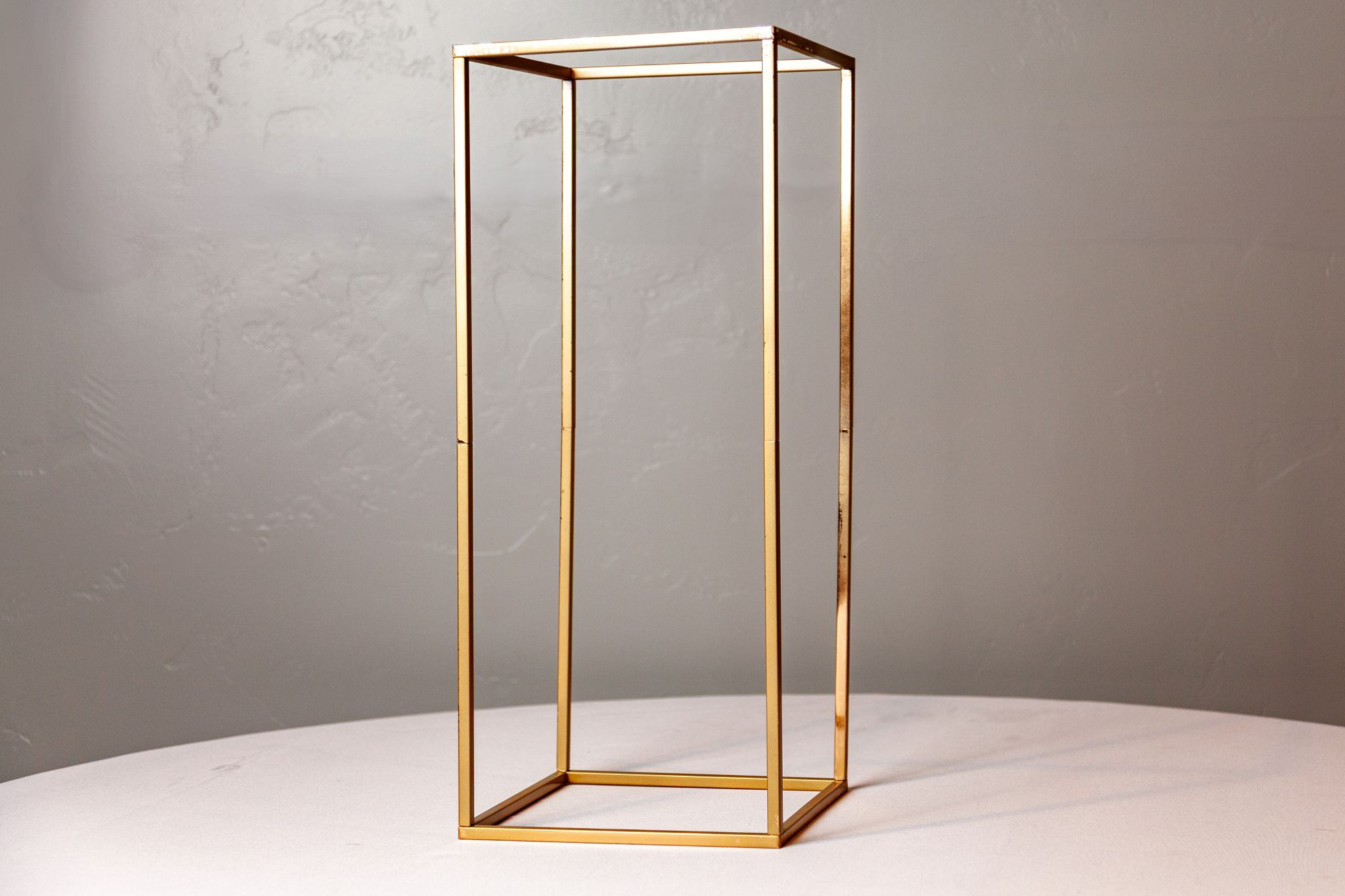 Single tall gold geometric column stand, ideal for modern wedding decor.
