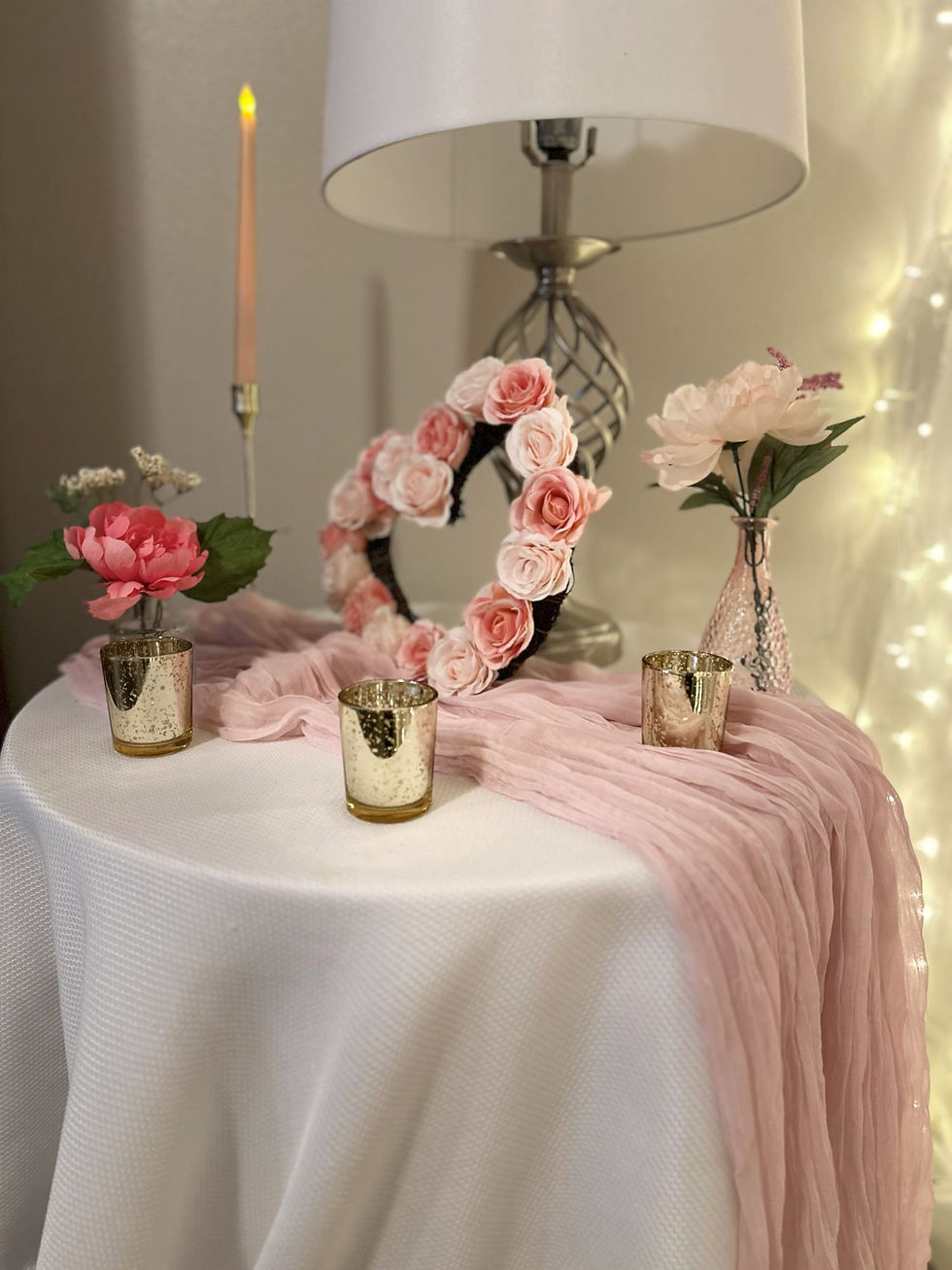 Thumbnail: Pink cheesecloth table runner on round table with roses and gold votives