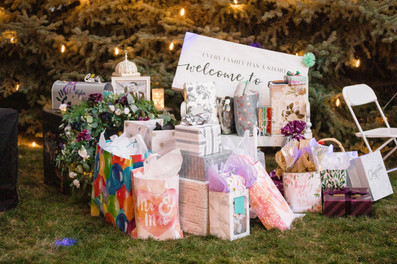 Cafe Lights wrapped around trees behind gifts at a Utah wedding reception.
