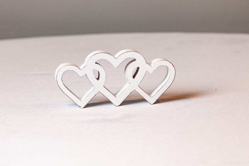 Triple white interlocking hearts decor on a white tablecloth, perfect for romantic wedding displays.