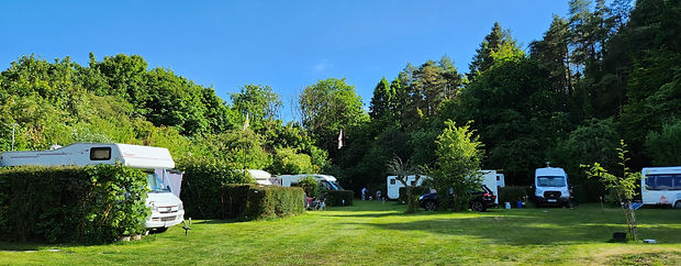 Panoramic view of campervans and caravans on their pitches at the South Western Outdoor Club, a naturist club.