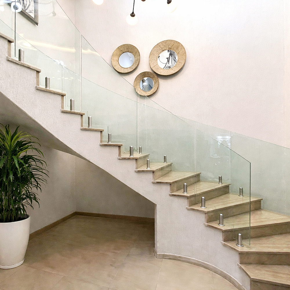Capra Projects | Floor mounted curved frameless glass balustrades for curved staircase