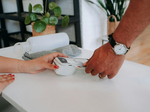 Customer tapping a card on an EFTPOS terminal at a small business counter.