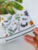 Thumbnail: White high-top canvas shoes with handpainted Halloween pumpkins, ghosts, and bats, facing left.