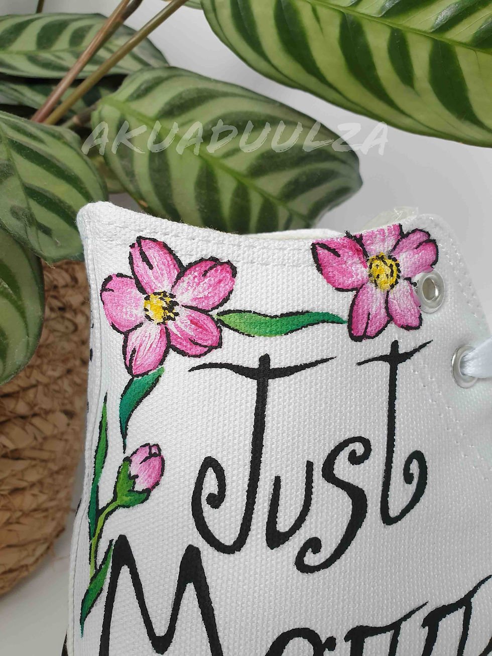 Thumbnail: Close-up of handpainted 'just married' text and pink flower on white canvas shoe, intricate detail.
