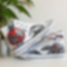 White high-top canvas shoes with handpainted Yin Yang Koi Fish, placed top of each other.