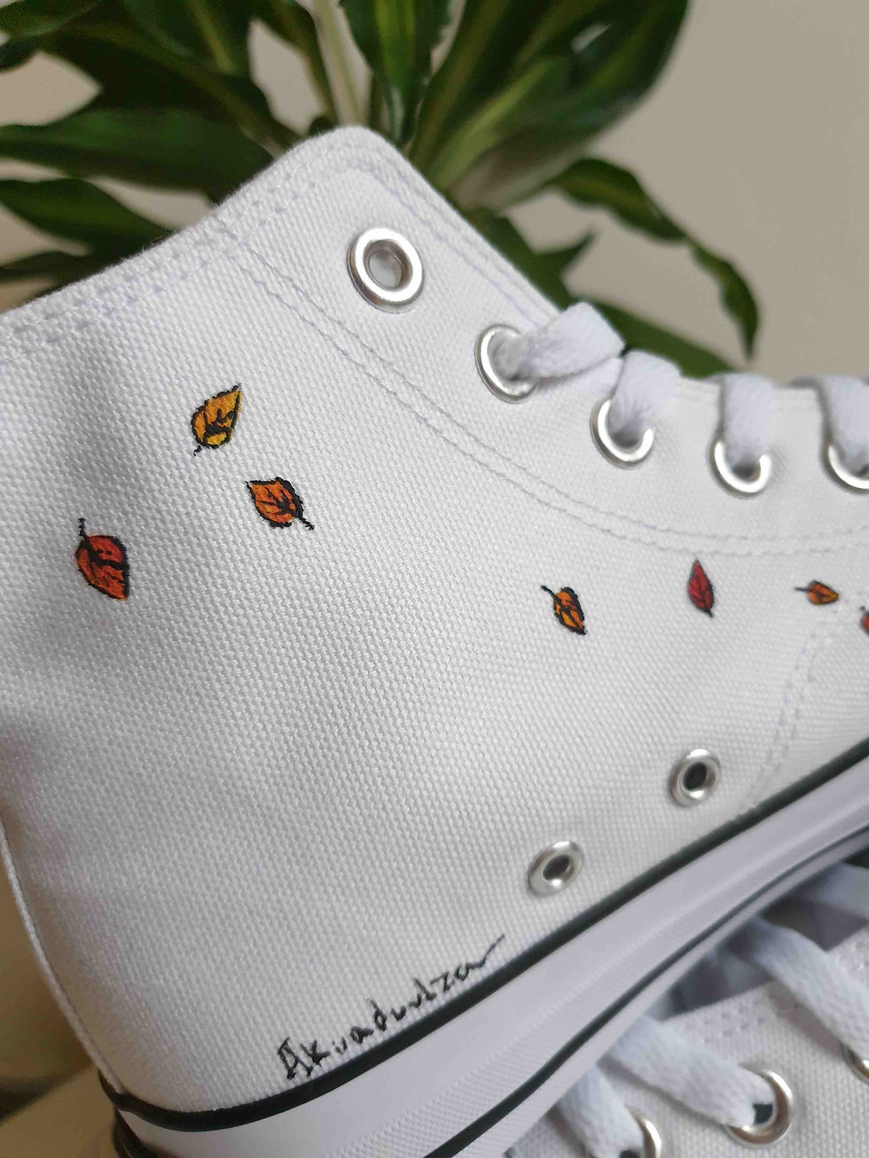 Thumbnail: Close-up of handpainted leaves on white canvas shoe, showing intricate detail.