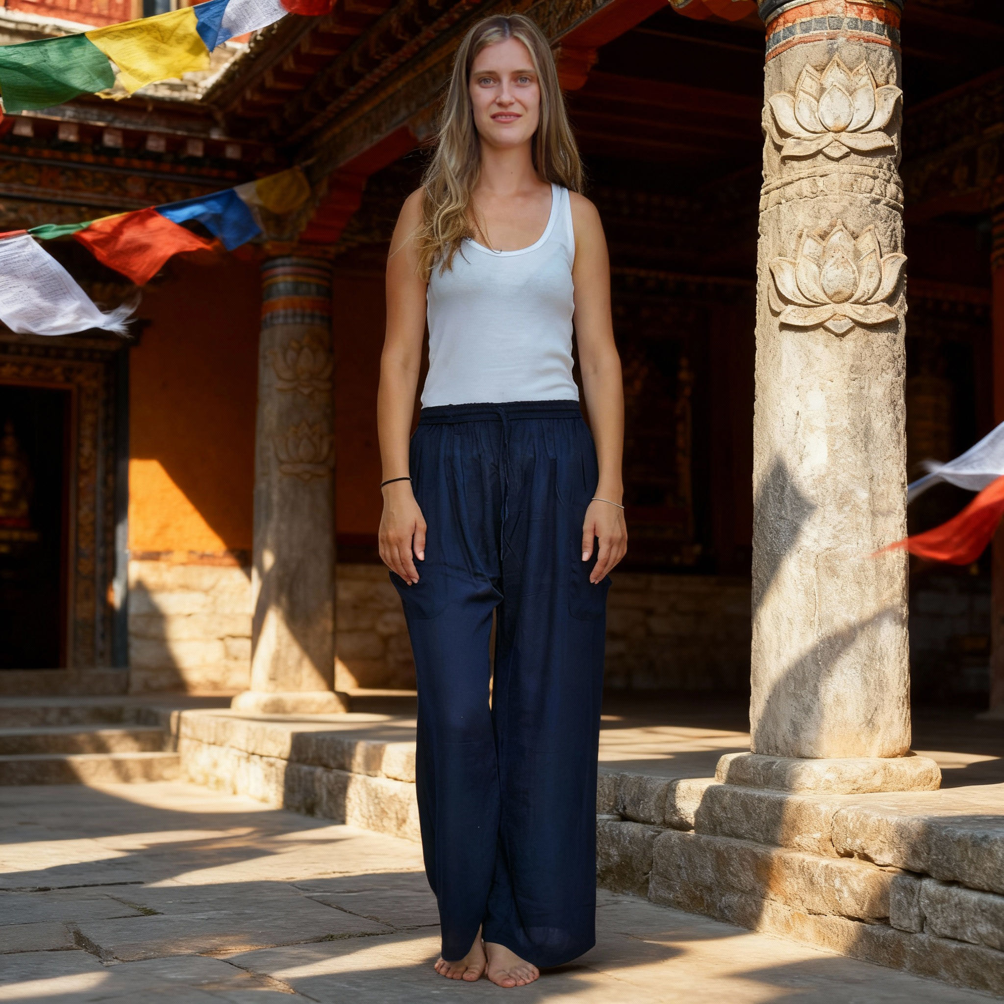Vista frontale dei pantaloni in rayon blu scuro, con uno sfondo architettonico e di bandiere.