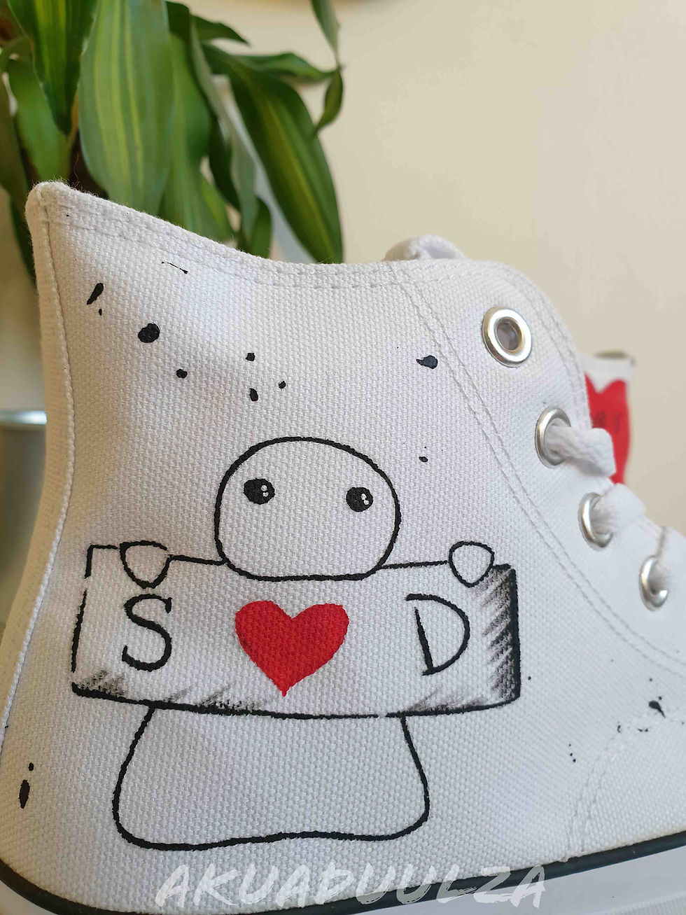 Thumbnail: Close-up of handpainted personalized heart on white canvas shoe, showing detail.