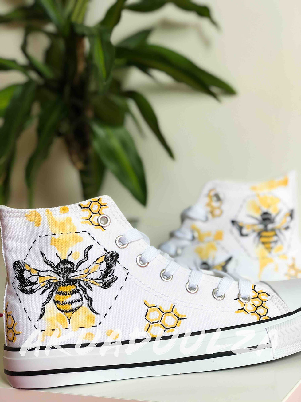 Thumbnail: White high-top canvas shoes with handpainted bee, facing right.