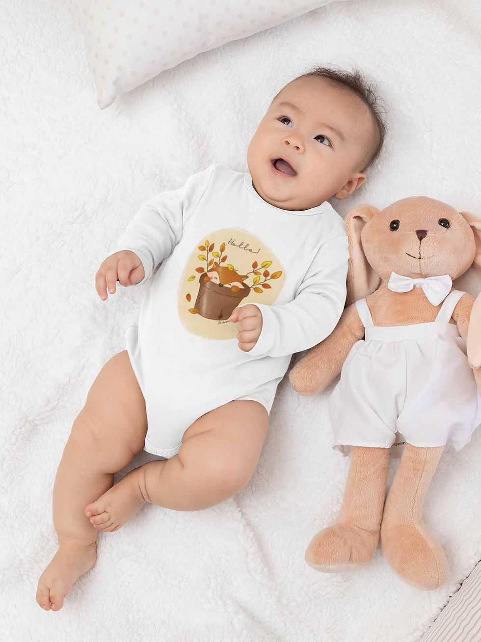 Baby wearing white cute fox bodysuit, lying next to a teddy bear.