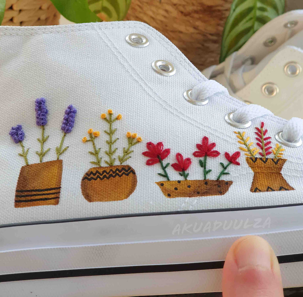 Thumbnail: Close-up of embroidered potted flowers on white canvas shoe.