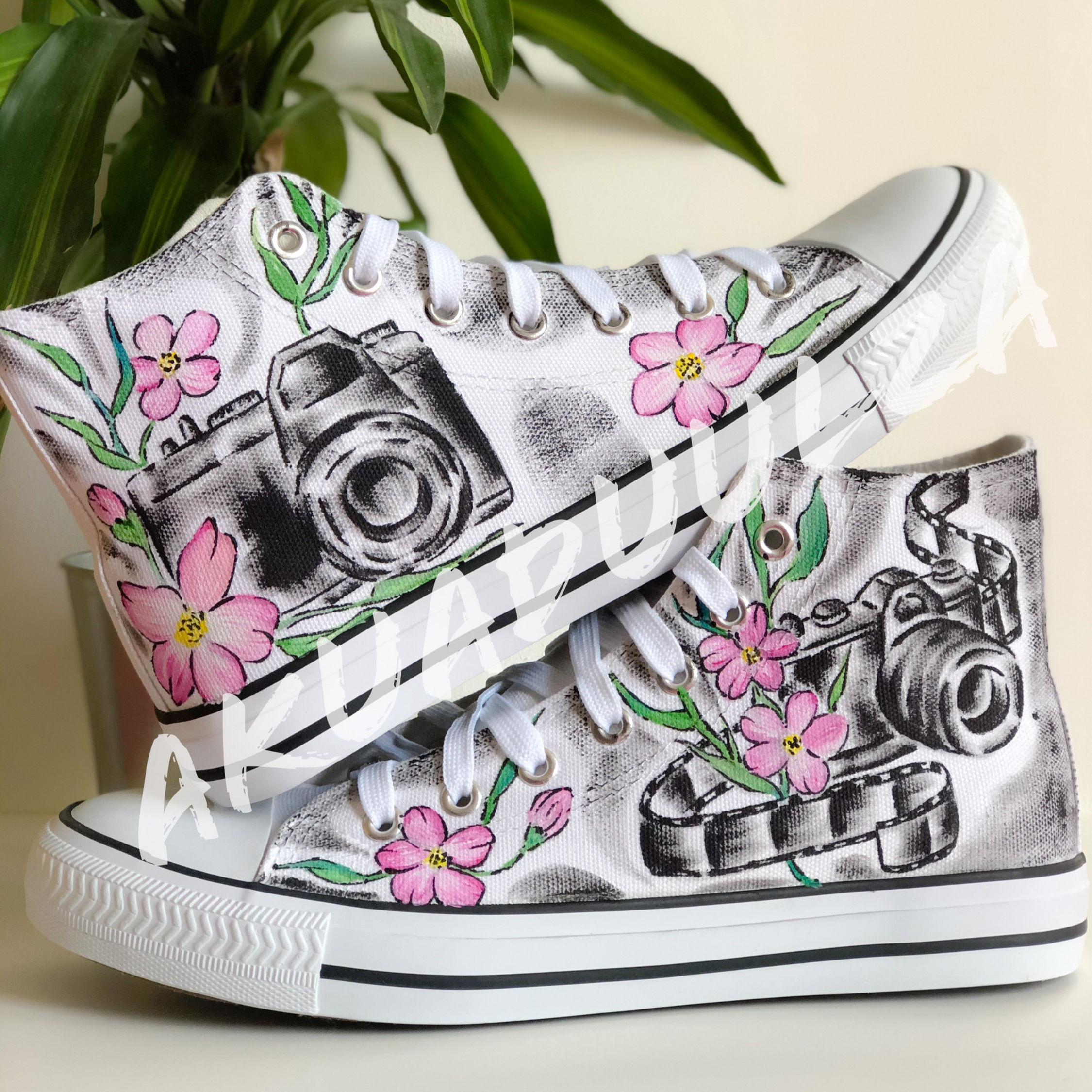 White high-top canvas shoes with handpainted Vintage Floral Camera, placed top of each other.