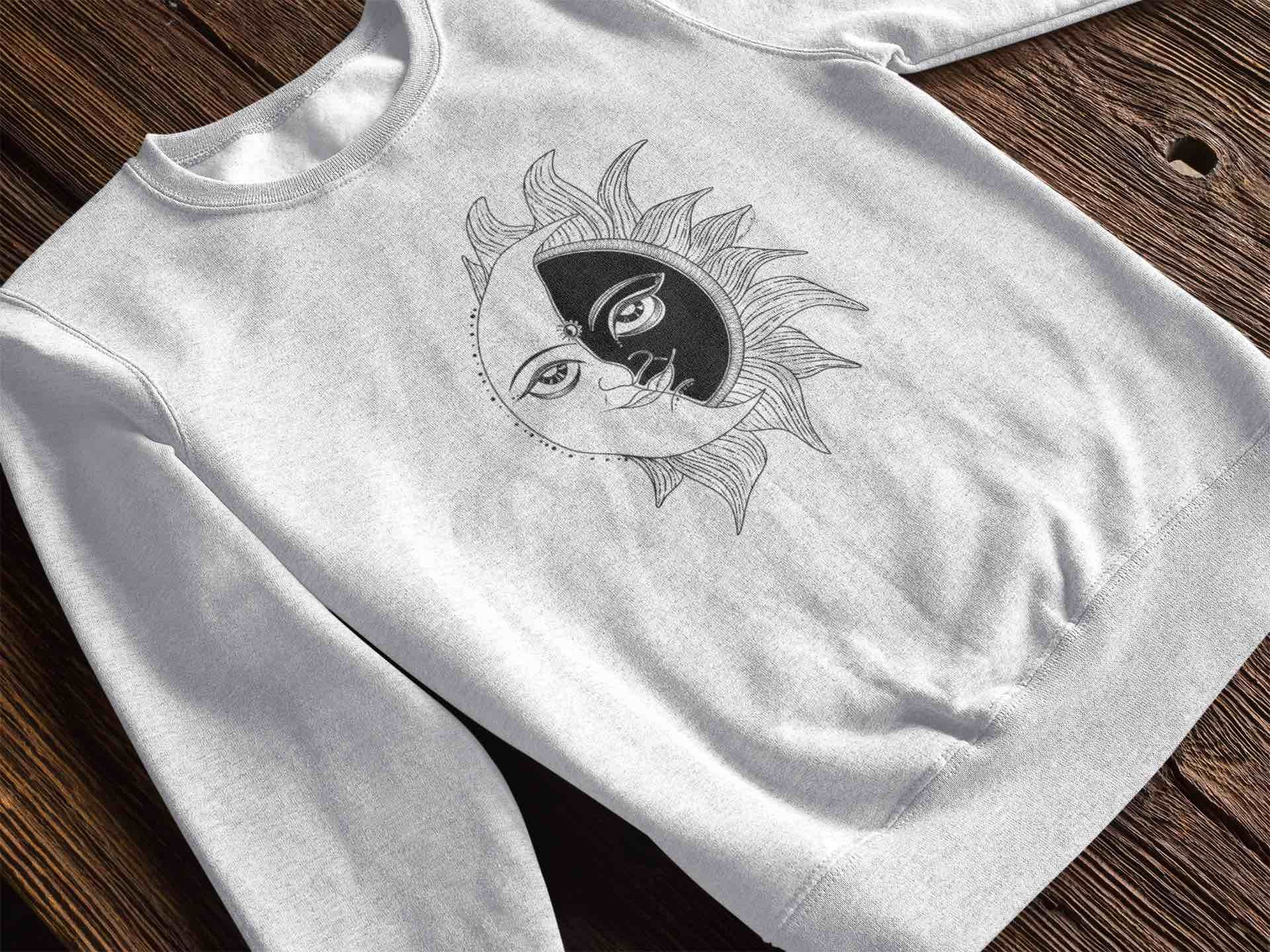 Grey sweatshirt with a detailed black and white sun and moon face graphic.