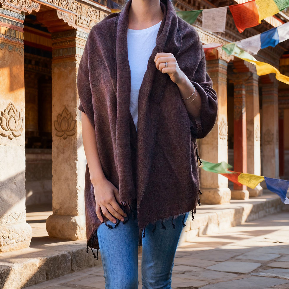 Donna, che guarda avanti, indossa uno scialle in lana yak marrone caffè in cortile con bandiere.