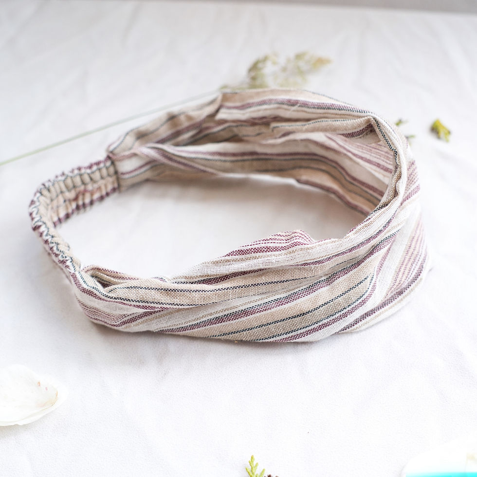 Fascia per capelli a righe multicolore su sfondo bianco con foglie e petali.