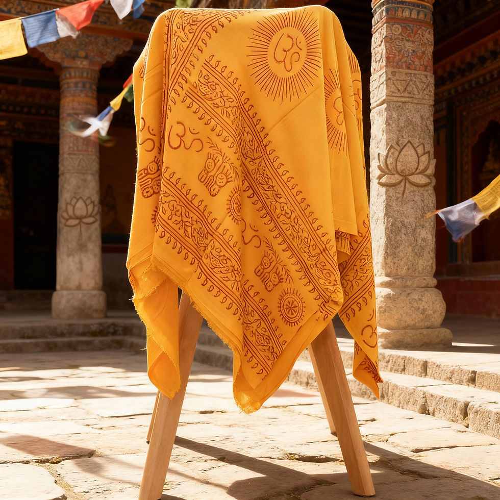 Sciarpa OM gialla drappeggiata su un supporto in legno in un cortile di pietra.