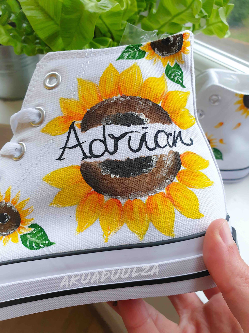 Thumbnail: Close-up of handpainted personalized sunflower on white canvas shoe, showing detail.