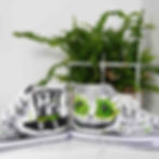 Thumbnail: White high-top canvas shoes with handpainted Green Cheshire cat and mad hatter, facing left and right..