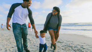 family walking together on the beach