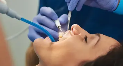 Persona siendo atendida por un dentista