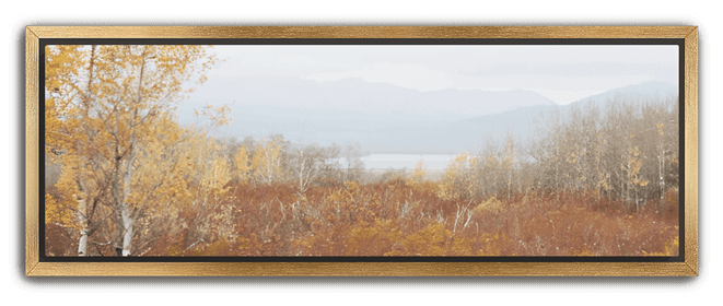 Soft autumn landscape with golden trees, red foliage, and misty mountains in the distance, set in a gold frame