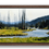 Thumbnail: A winding river flows through bright green meadows and sparse pines beneath distant blue hills, set in a dark espresso frame