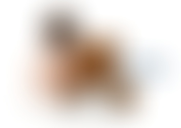 A diapered baby sits with a brown teddy bear on a white background. Text reads "Give a little, help a lot!" Mood is warm and comforting.