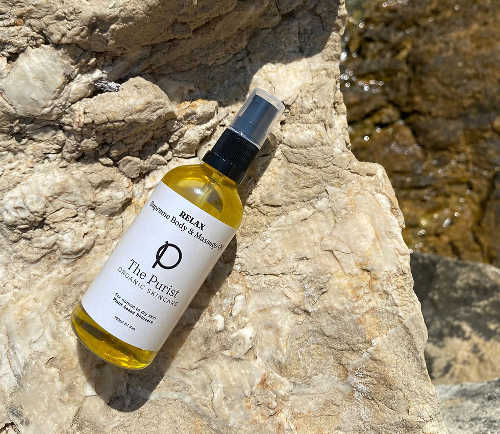 Bottle of Relax Body and Massage Oil lying on the rocks by The Purist Organic Skincare
